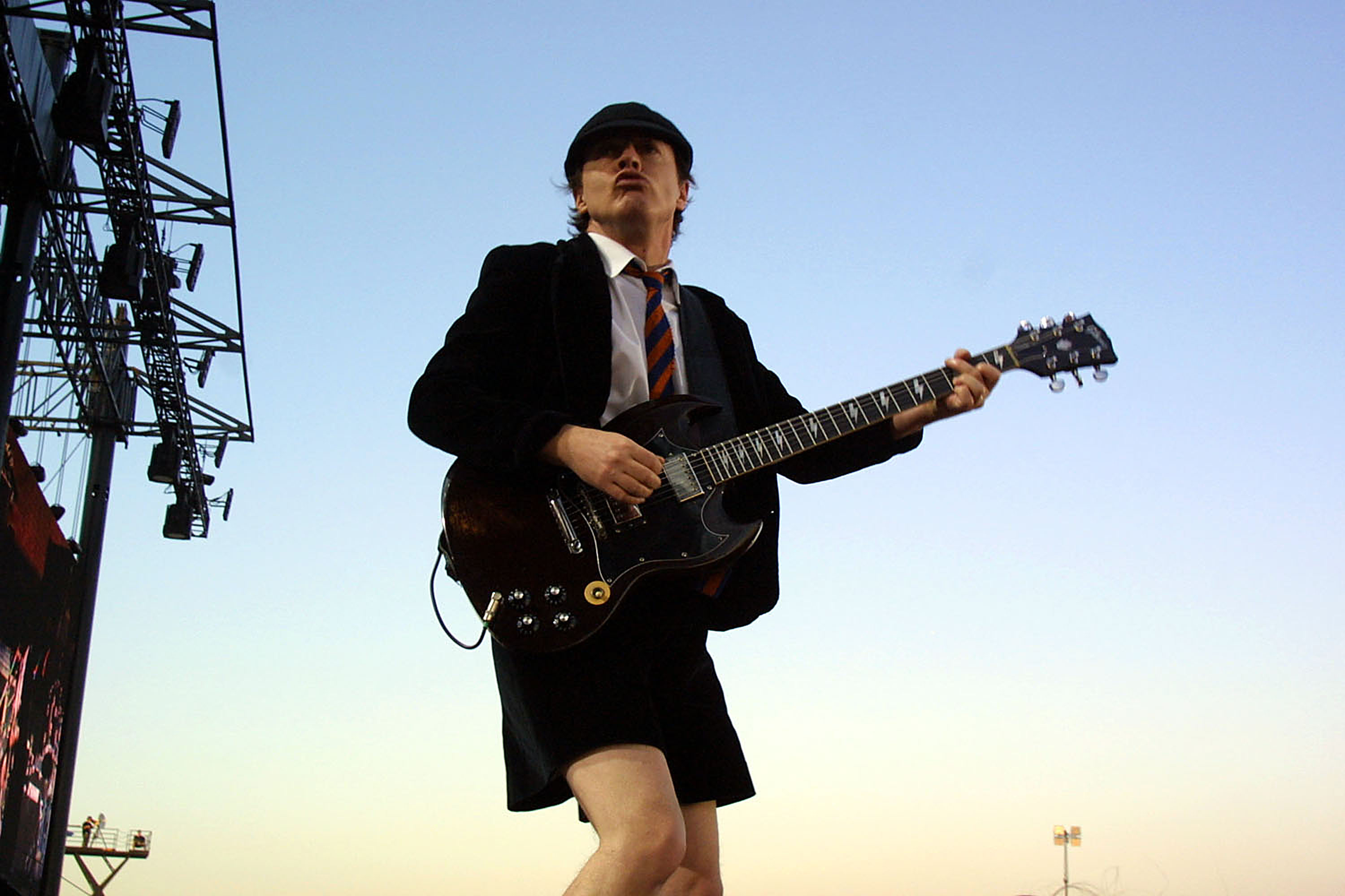 Янг ac dc. Angus young AC/DC. AC DC Angus young молодой. Соло гитарист AC DC. Angus young галстук.